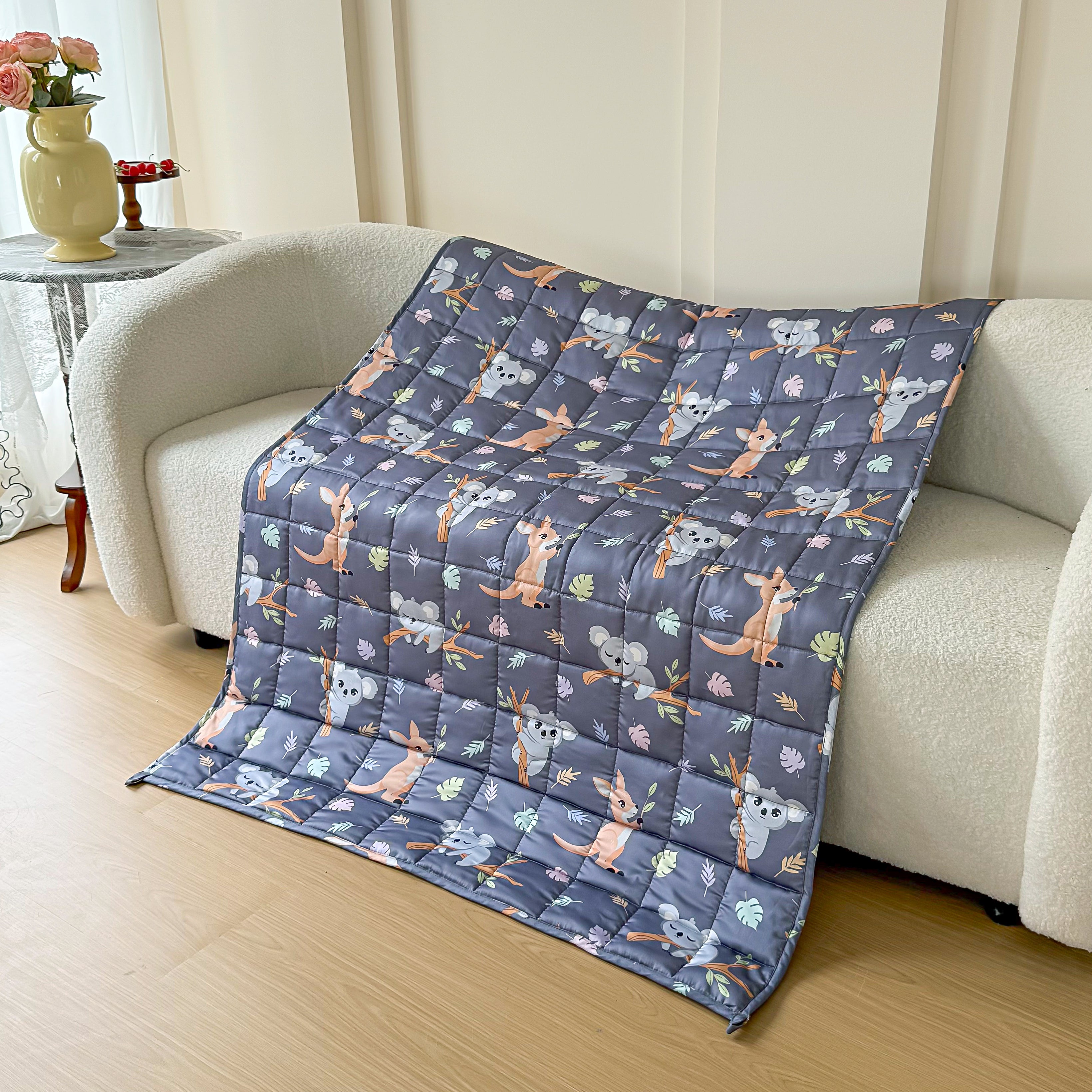 Quilt with animal pattern blanket draped over a sofa in a living room