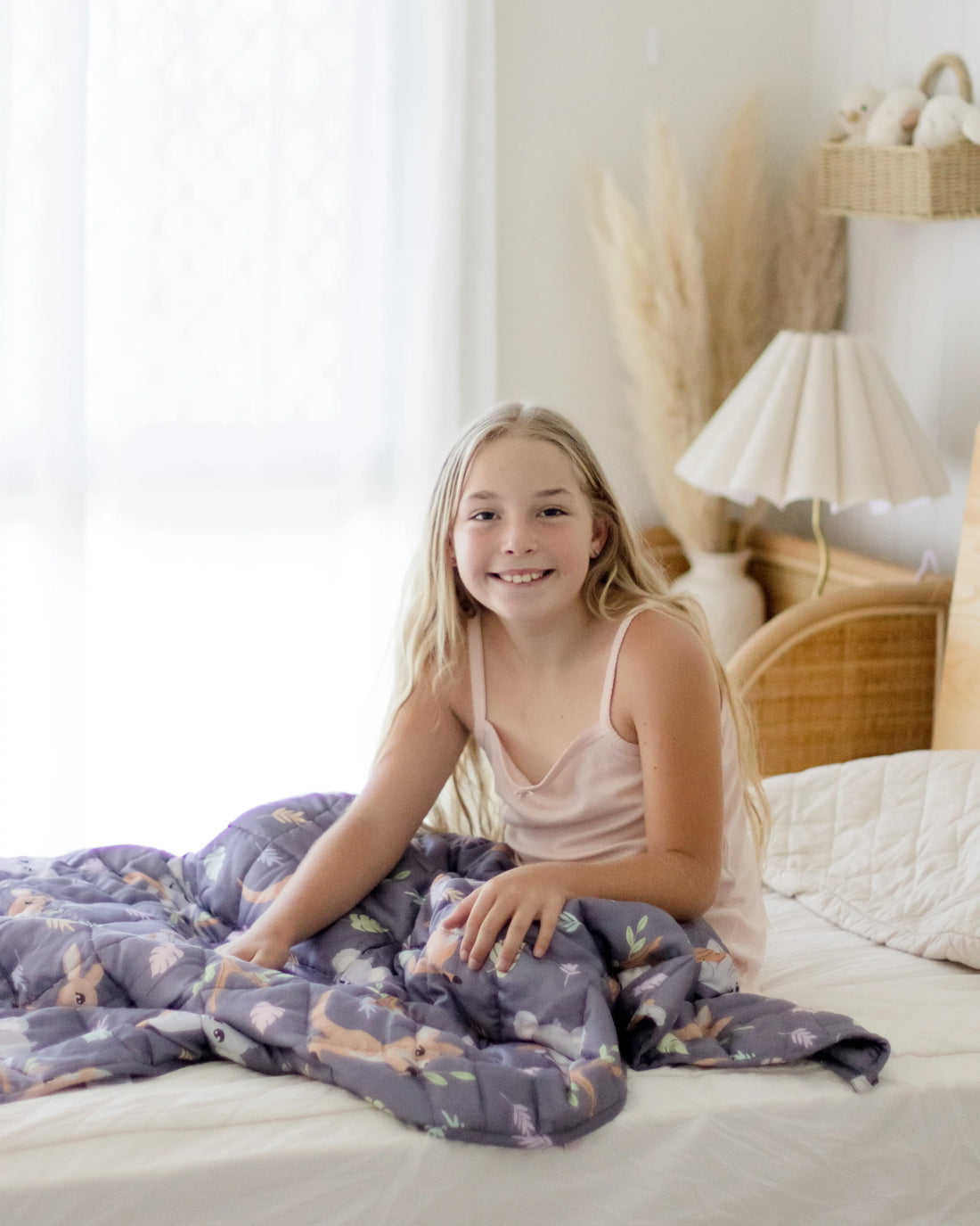 A young girl is sitting wrapped in a blanket.